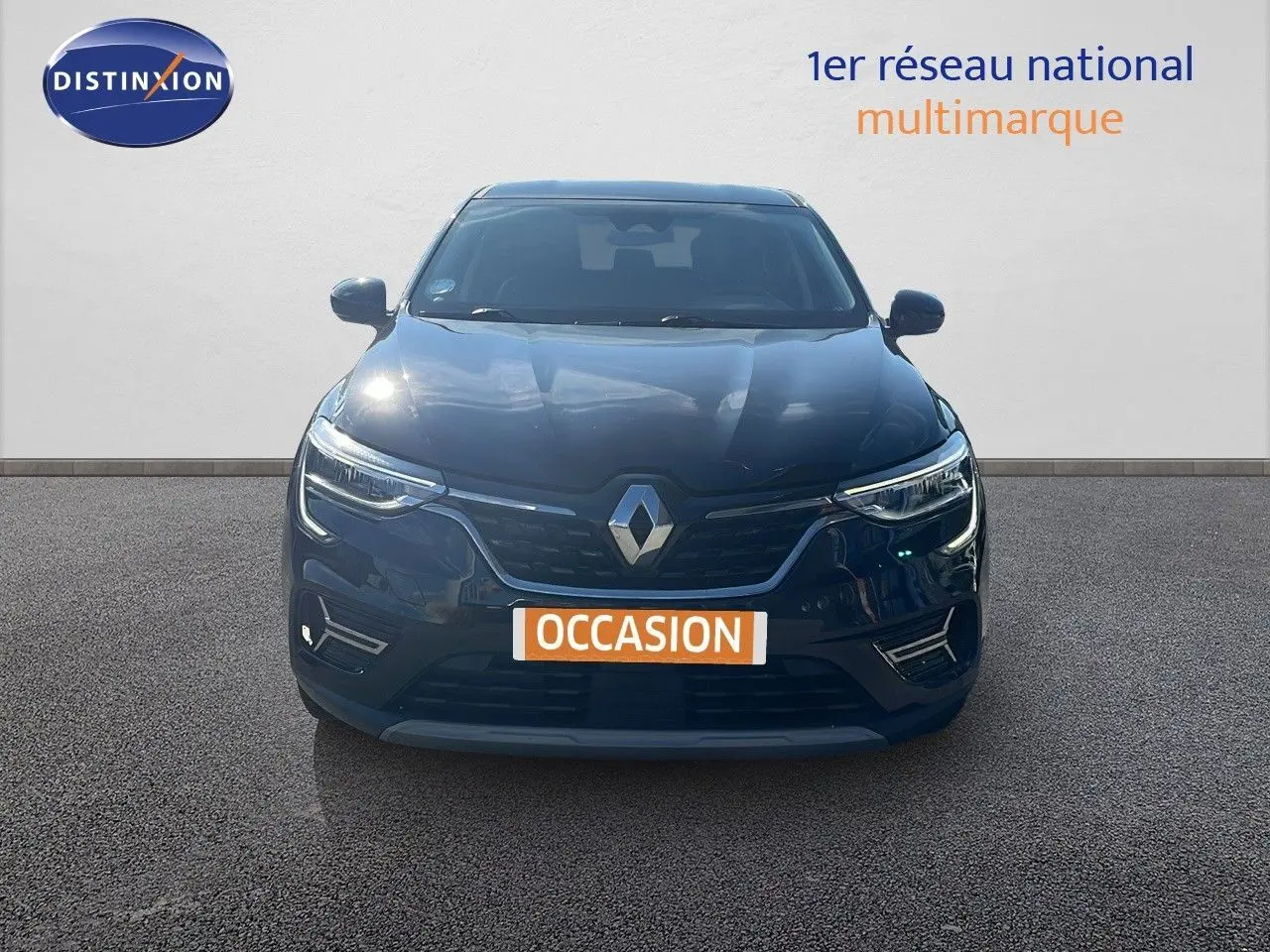 Vue frontale d'un Renault Arkana noir métal 2023 avec calandre distinctive et phares LED allumés.