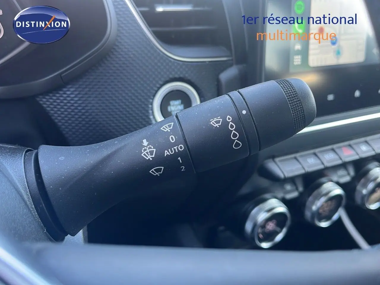 Gros plan sur la commande d'essuie-glace du Renault Arkana noir métal 2023, avec tableau de bord et écran tactile en arrière-plan.