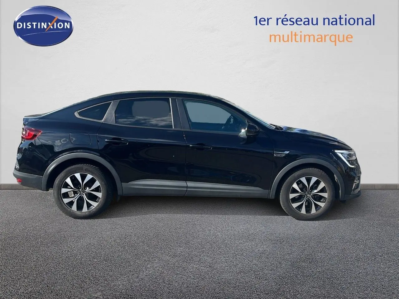 Vue de profil côté gauche du Renault Arkana noir métal 2023, version hybride avec jantes bicolores et lignes fluides.