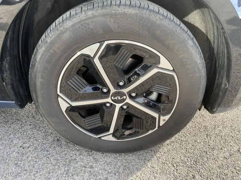 Gros plan sur la jante noire et argentée du KIA NIRO 2024, avec logo central, montée sur pneu Kumho.