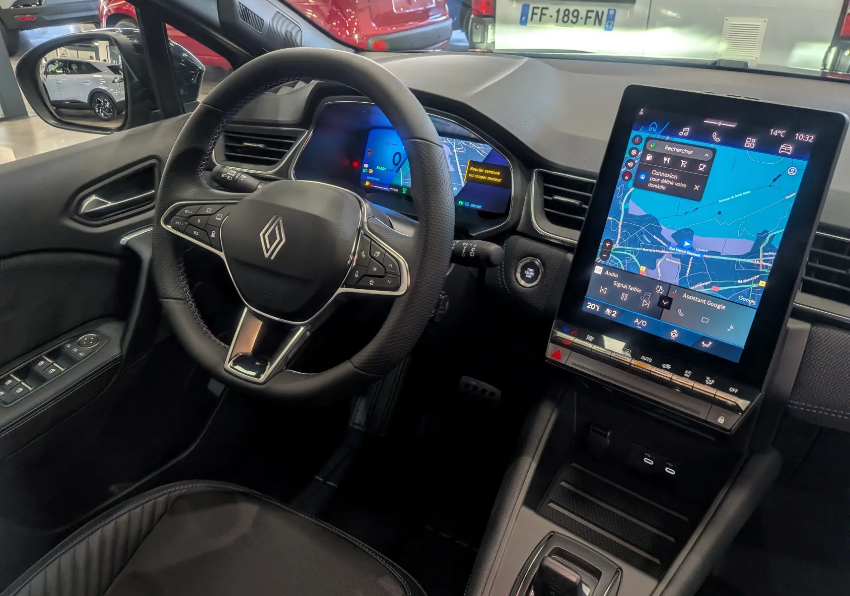 Vue intérieure côté conducteur de la Renault Symbioz E-TECH hybride, avec tableau de bord numérique et écran tactile central.