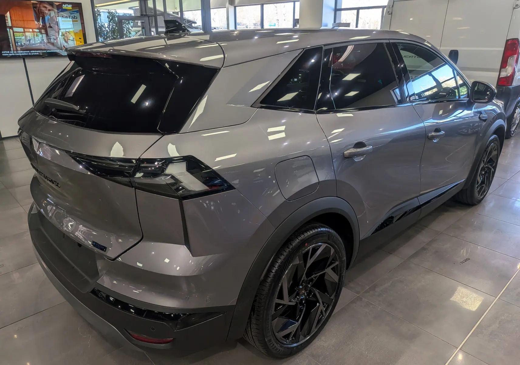 Vue 3/4 arrière droite du Renault SYMBIOZ gris Cassiopé avec vitres teintées et jantes noires en concession.