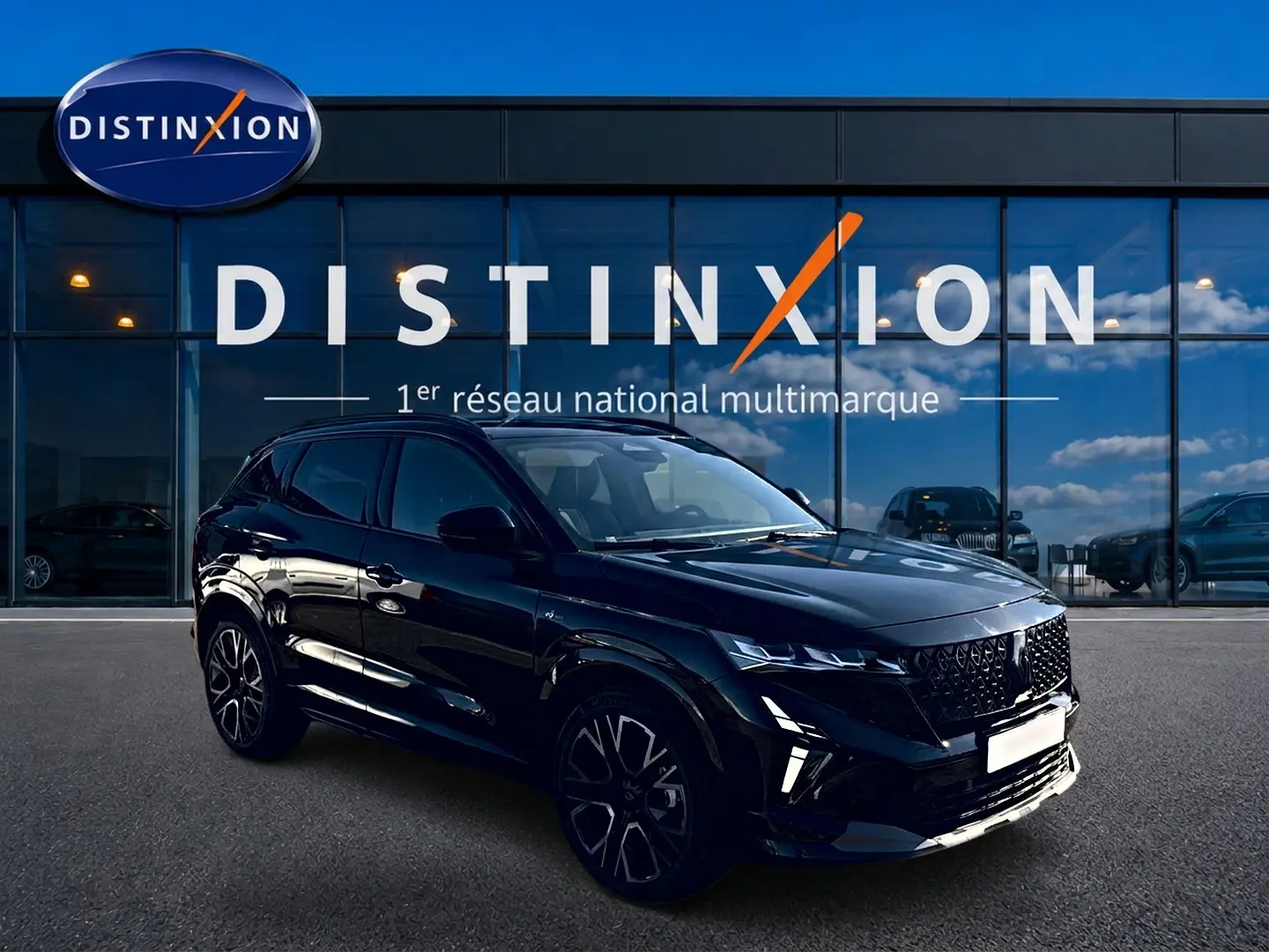 Renault Austral noir en 3/4 avant droit, avec calandre noire et jantes alu distinctives, devant un showroom Distinxion.