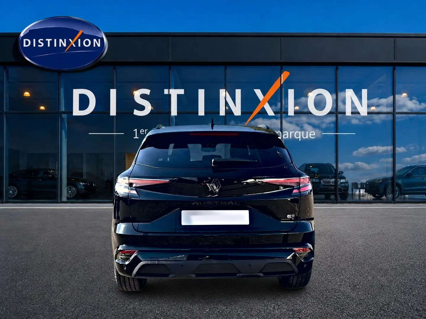 Vue arrière d'un Renault Austral noir 1.2 e-tech full hybrid 200 esprit alpine devant une vitrine Distinxion.