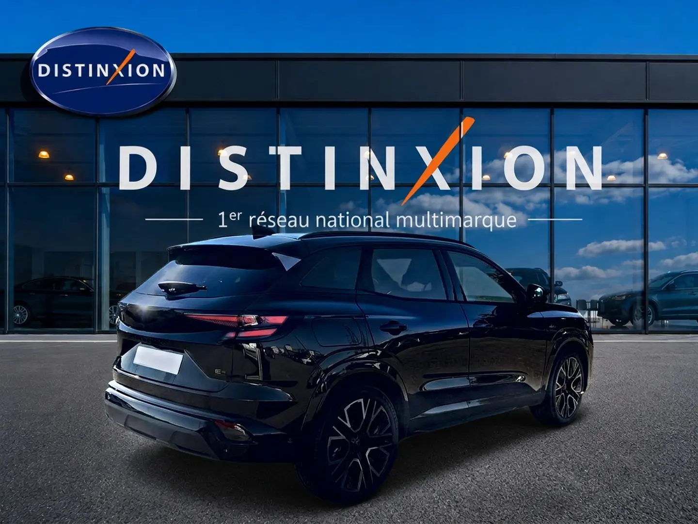 Vue 3/4 arrière droite du Renault Austral noir avec jantes alu et feux arrière LED, devant une vitrine Distinxion.