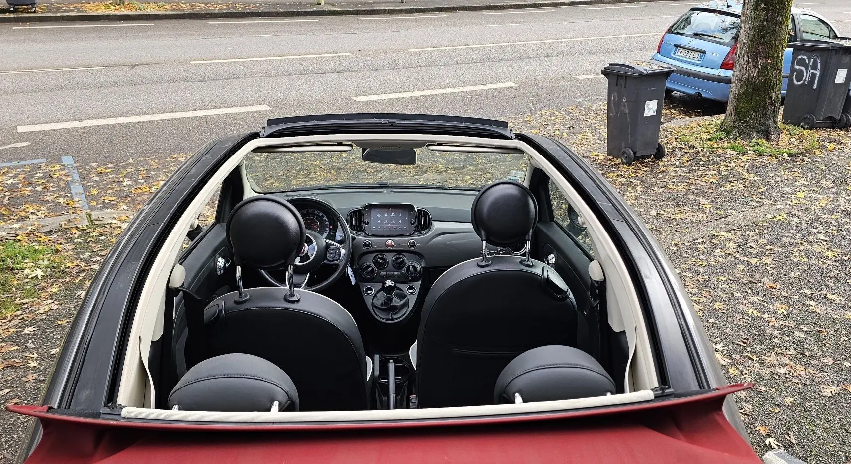 Vue intérieure du tableau de bord et volant d'une Fiat 500C 2019 avec boîte manuelle et finitions noires.