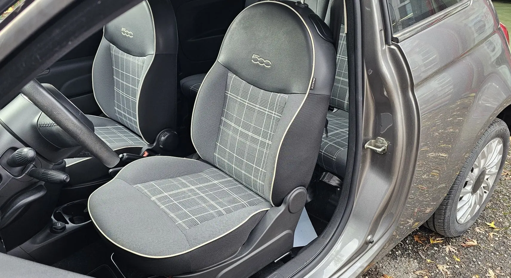 Profil droit d'une FIAT 500C grise électroclash avec toit rouge, sur fond neutre extérieur.