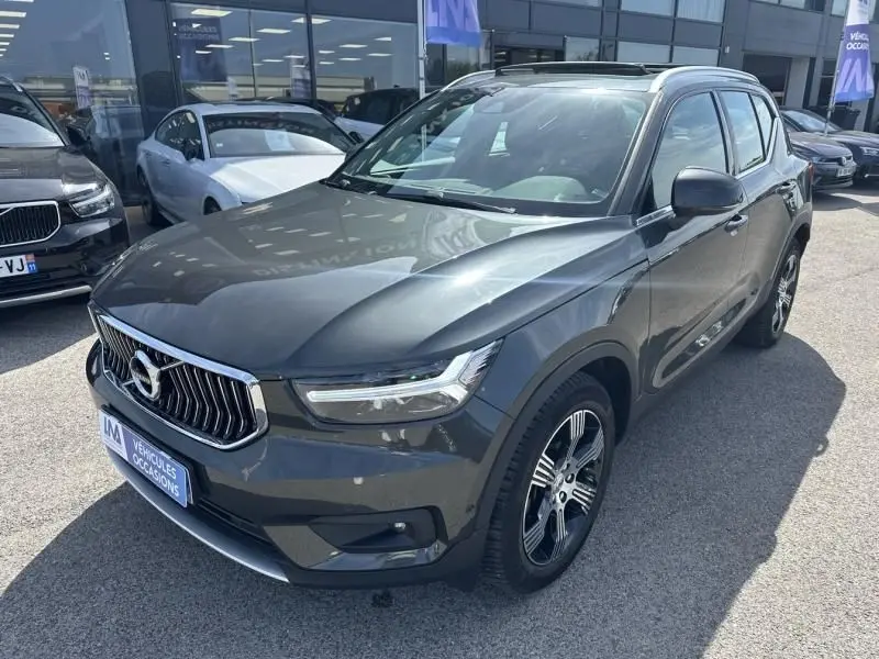 Volvo XC40 T4 190 CV gris foncé métal en 3/4 avant droit, avec calandre chromée et jantes alliage distinctives.