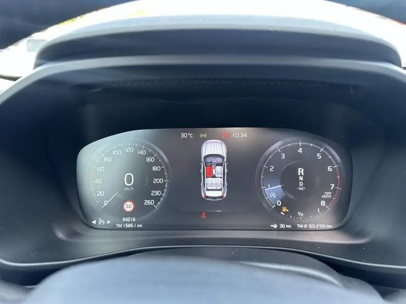 Tableau de bord numérique du Volvo XC40 T4 2019, affichant la vitesse, régime moteur et vue 3D du véhicule en gris foncé métal.