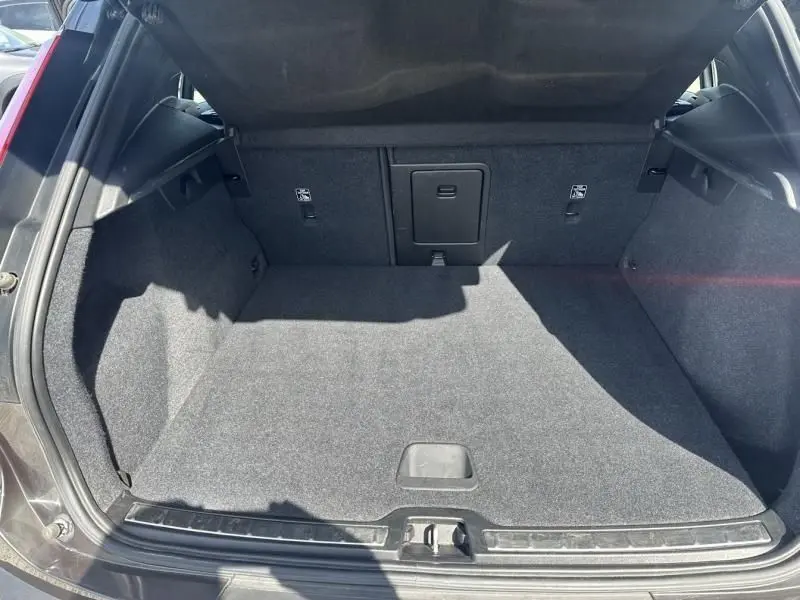 Coffre ouvert vu de l'arrière d'un Volvo XC40 gris foncé métal, montrant un espace de chargement propre et spacieux.