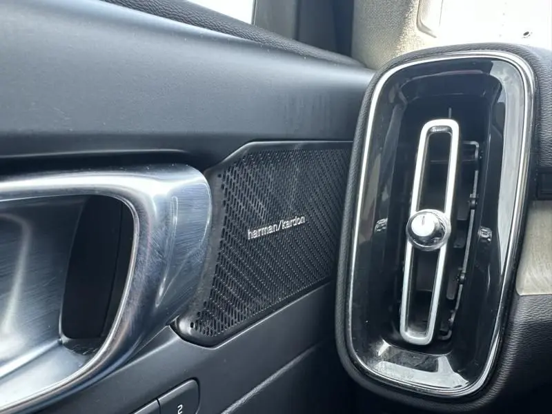 Détail intérieur côté gauche du Volvo XC40 T4 2019, avec haut-parleur Harman/Kardon et sortie d'air verticale noire.
