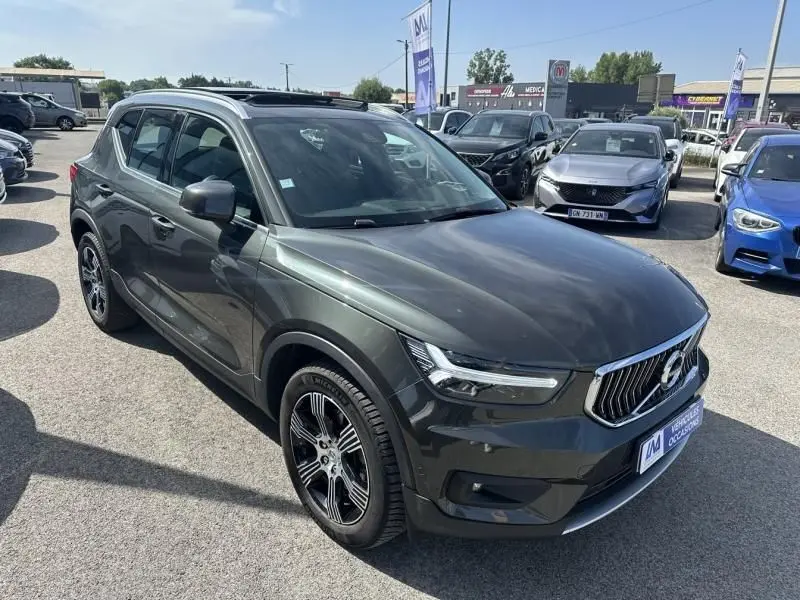 Volvo XC40 T4 gris foncé métallisé vu en 3/4 avant droit avec jantes alliage et calandre chromée.