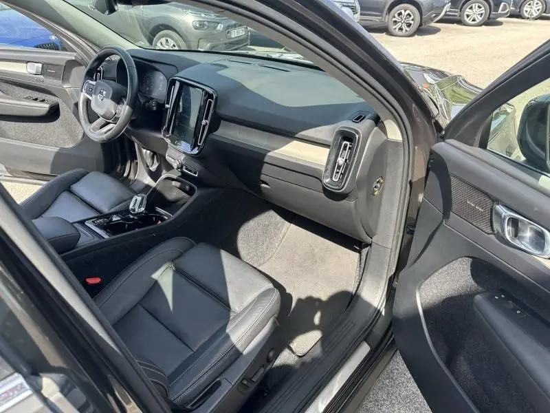 Intérieur du Volvo XC40 T4 2019 en gris foncé, vue côté passager avec tableau de bord moderne et sièges cuir noirs.