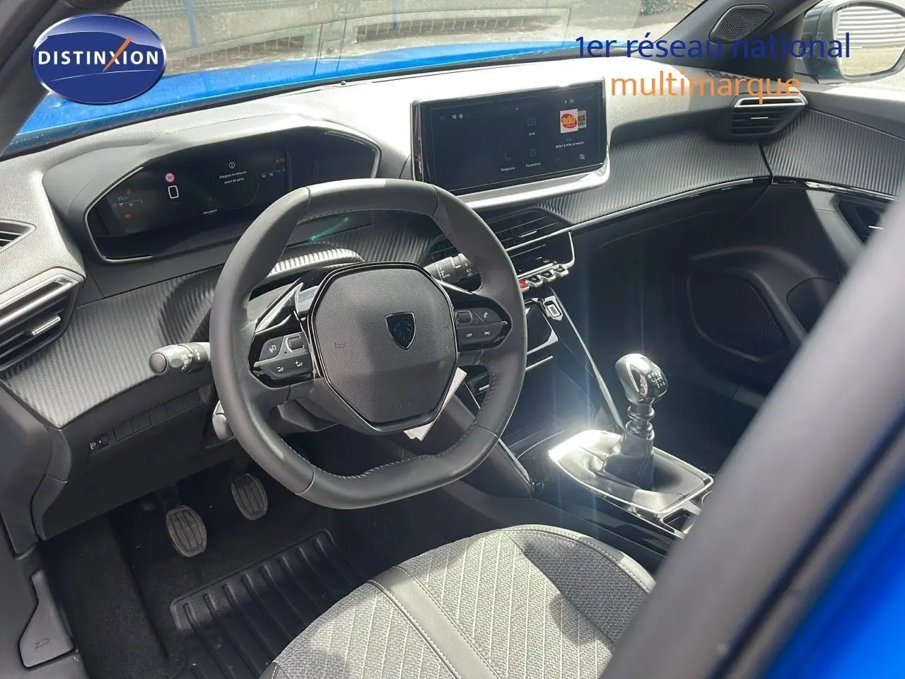 Intérieur du Peugeot 2008 2024 bleu Vertigo, vue côté conducteur sur volant, tableau de bord digital et levier de vitesse manuel.