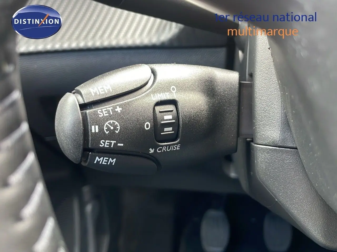 Gros plan sur la commande de régulateur de vitesse du Peugeot 2008 bleu Vertigo Metal, côté gauche du volant.