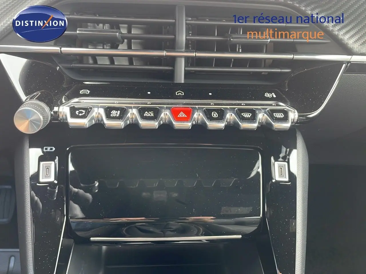 Tableau de bord du Peugeot 2008 2024 avec commandes centrales et boutons métalliques en gros plan.