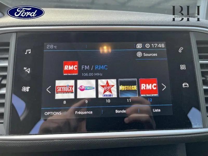 Écran tactile multimédia de la Peugeot 308 SW 2021 affichant les stations radio avec interface moderne et commandes tactiles.