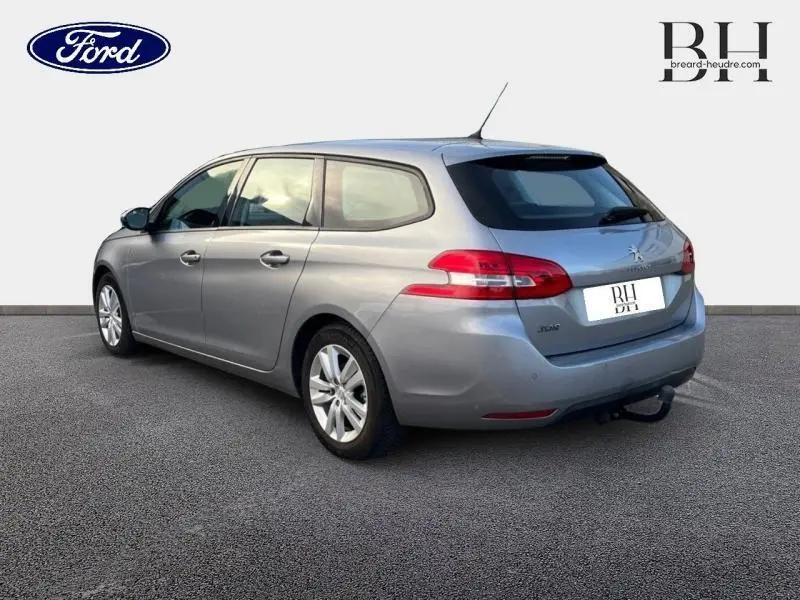 Peugeot 308 SW gris Artense vue 3/4 arrière droit, avec feux arrière LED et attelage de remorque visible.