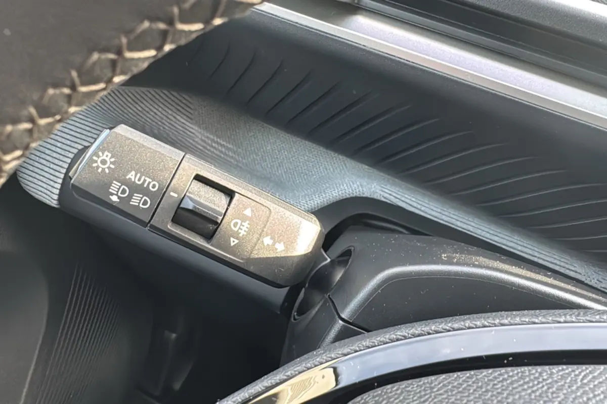 Gros plan sur la commande des feux et clignotants du Citroën C3 Aircross noir perla nera, intérieur côté gauche.