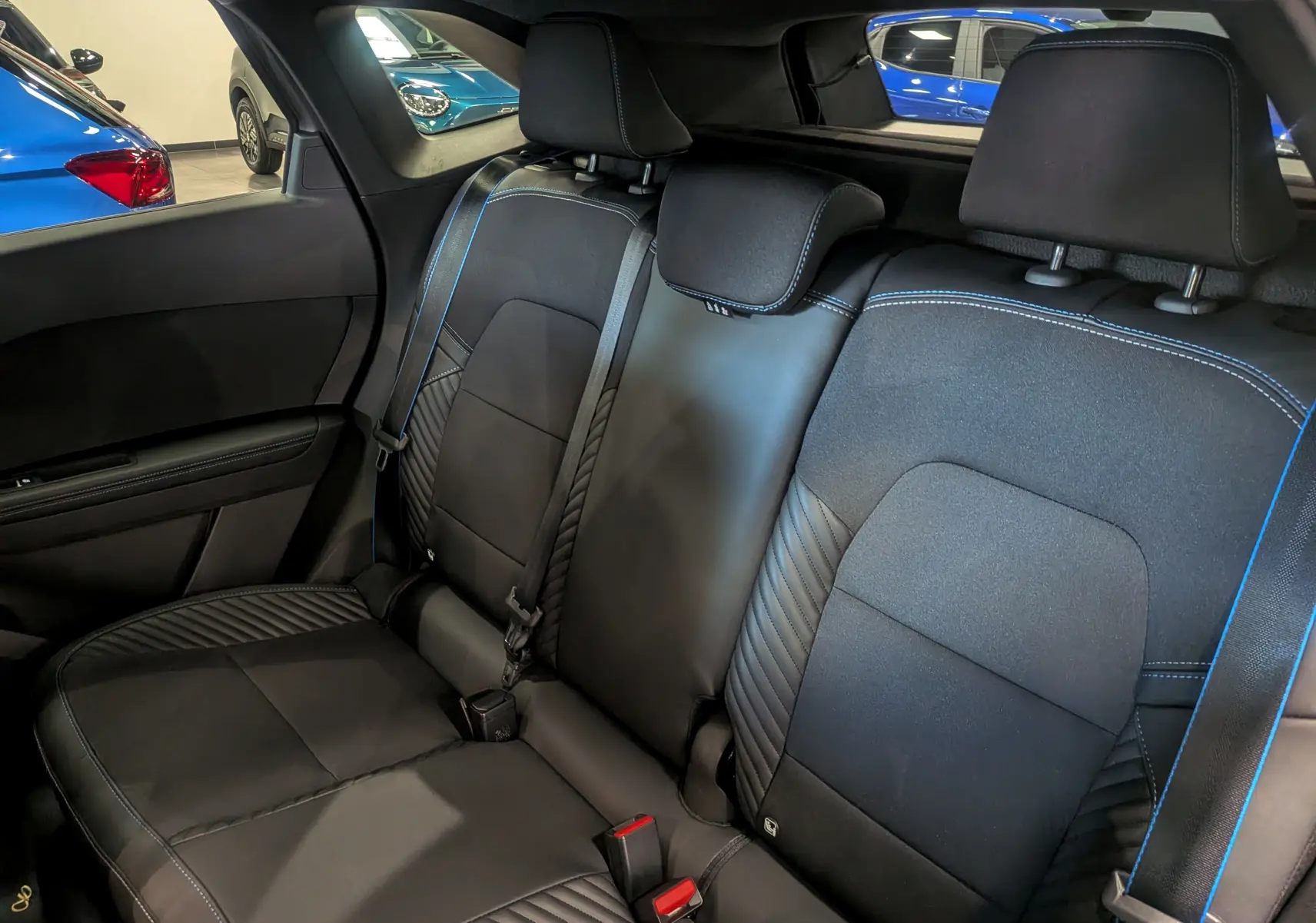 Vue intérieure arrière des sièges en cuir noir avec surpiqûres bleues du Renault Symbioz E-TECH Full Hybrid 2026.