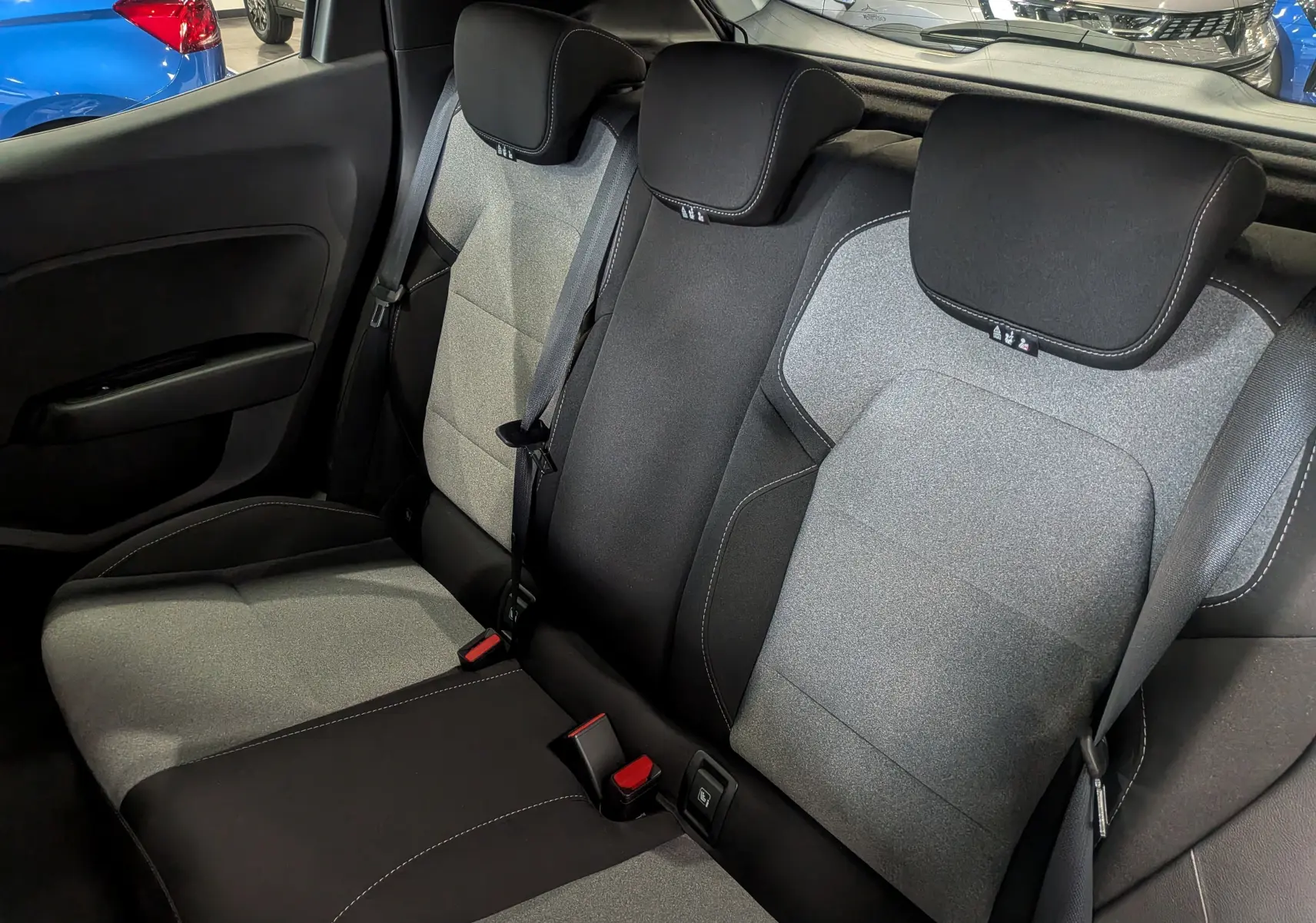 Vue intérieure arrière montrant les sièges tissu bicolores gris et noir de la Renault Clio V Blue dCi 100 CH Evolution.