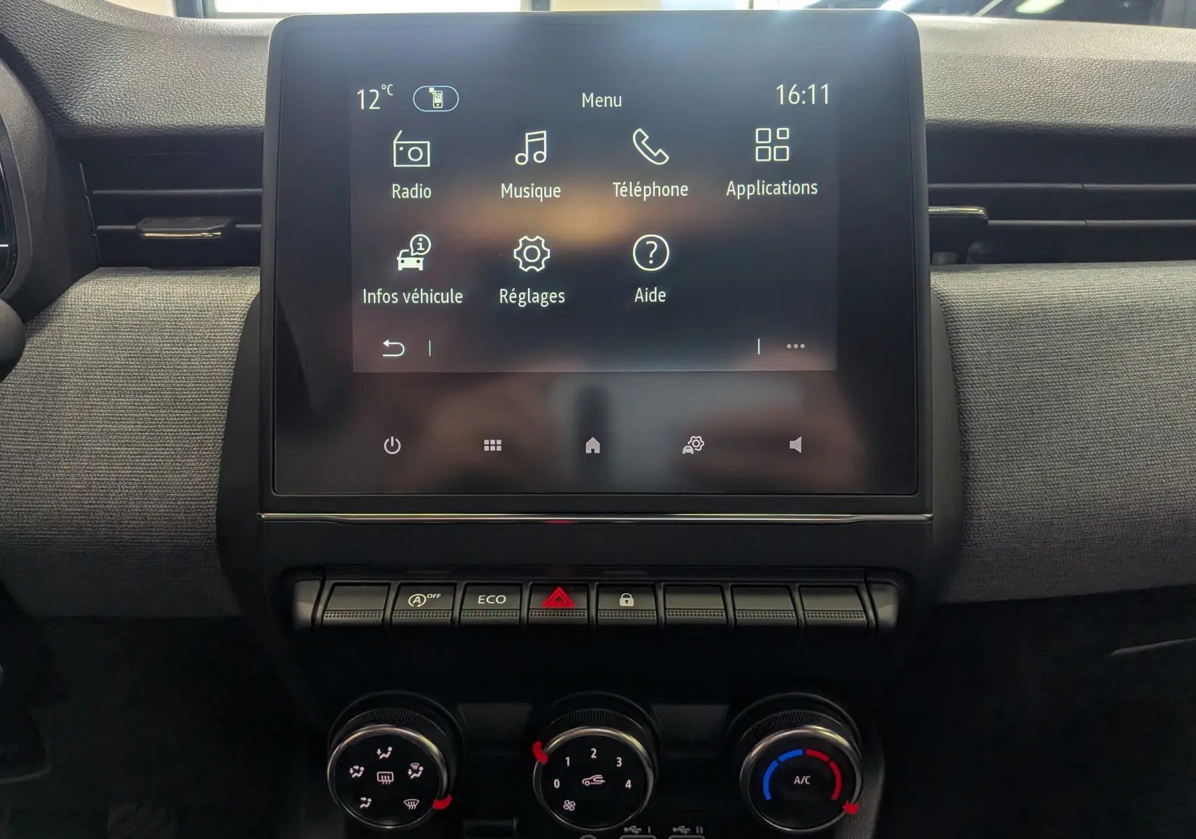 Vue intérieure centrée sur l'écran tactile et la console de commande de la Renault Clio V Blanc Glacier 2025.