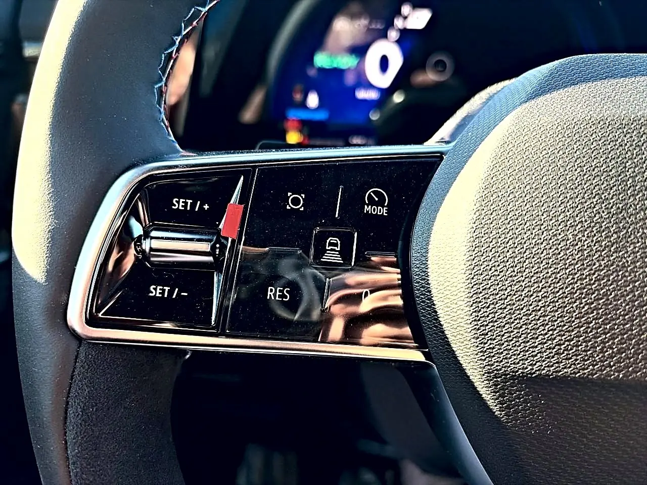 Gros plan sur les commandes de régulateur de vitesse au volant noir du Renault Austral 1.2 e-tech hybride.