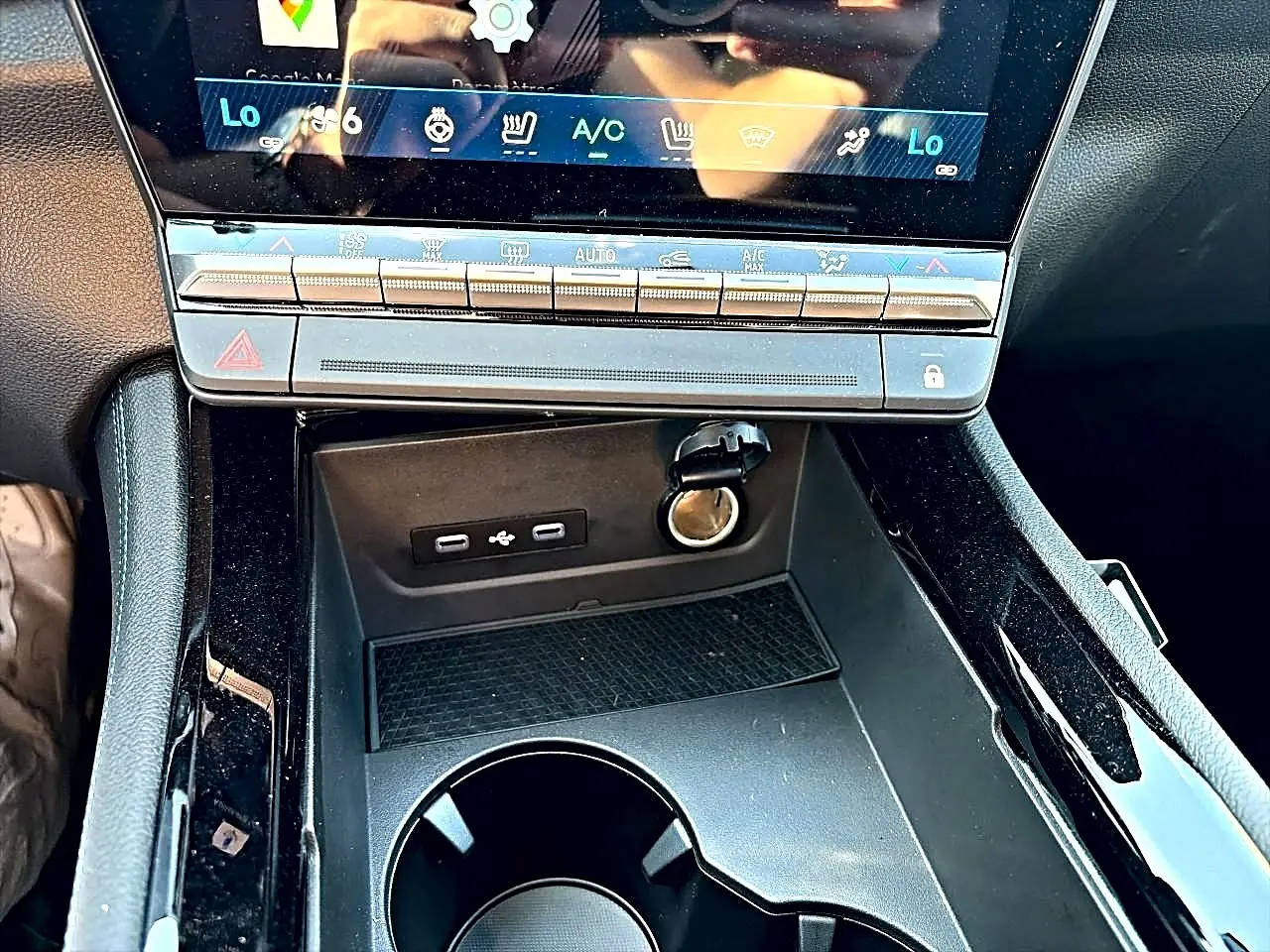 Vue rapprochée de la console centrale noire du Renault Austral 1.2 e-tech, avec ports USB et prise 12V visibles.