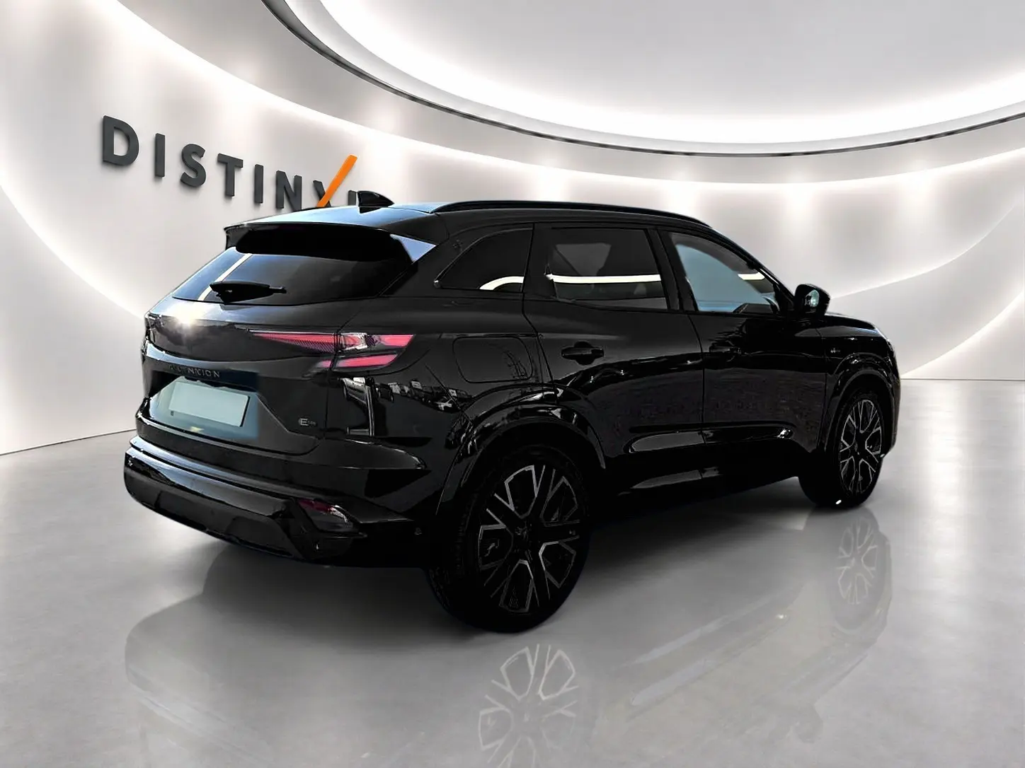 Renault Austral noir en 3/4 arrière droit, avec jantes alu noires et feux arrière LED fins, dans un showroom lumineux.