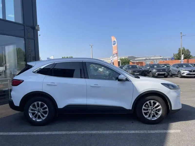 Profil côté gauche d'un Ford Kuga blanc 2020, version 2.0 EcoBlue 150 MHEV Titanium, sur parking extérieur.