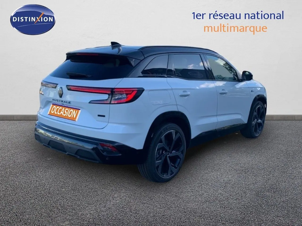 Vue 3/4 arrière droite d’un Renault Austral blanc métal avec toit noir et jantes noires sur fond neutre.