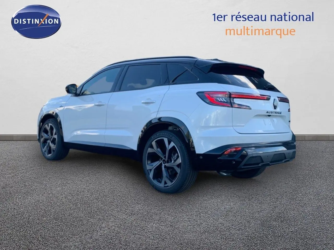 Vue 3/4 arrière droite du Renault Austral blanc métal avec toit noir, soulignant ses jantes noires et feux LED distinctifs.