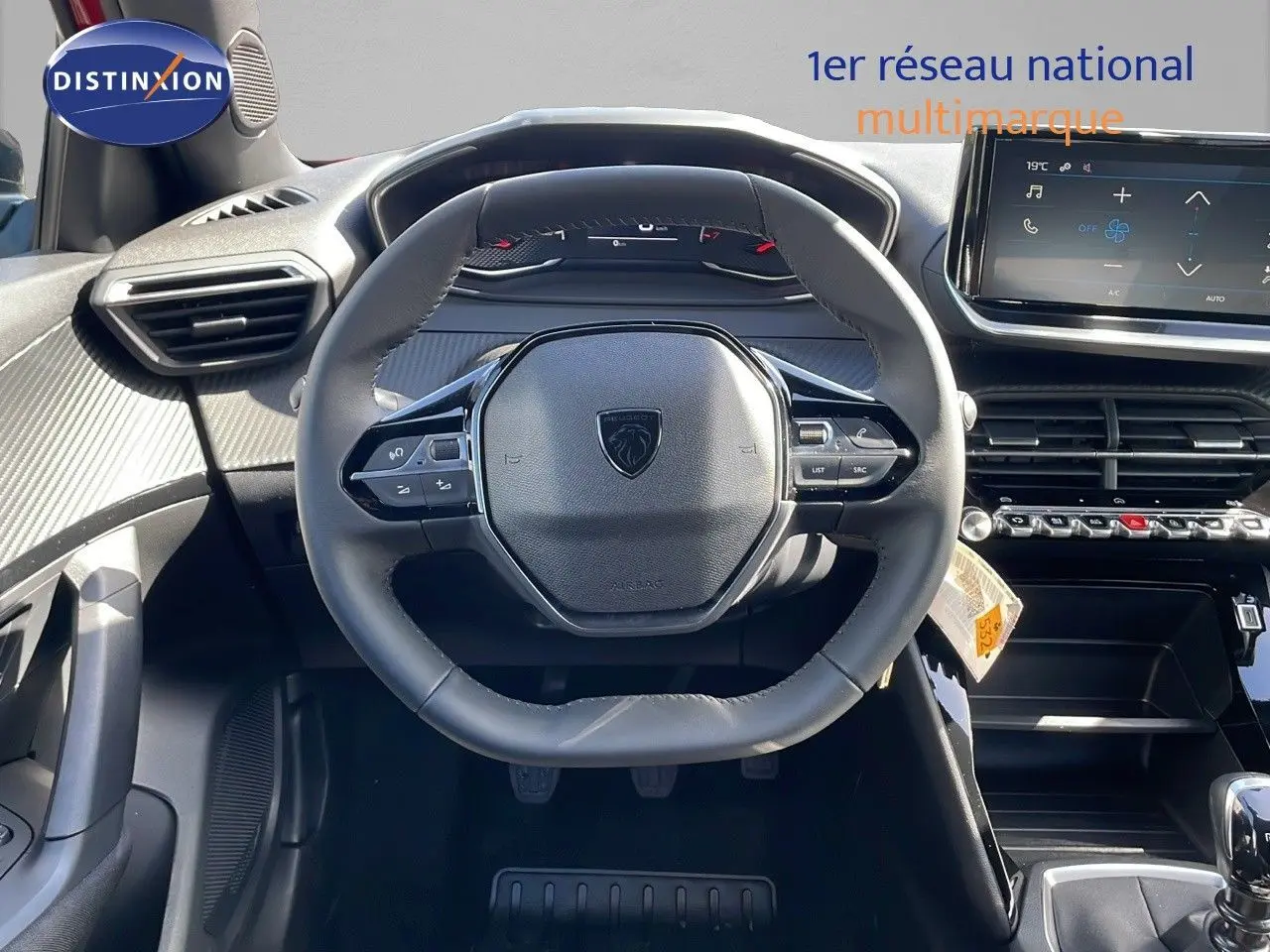 Vue centrée sur le volant et le tableau de bord du Peugeot 2008 rouge Elixir Metal, avec écran tactile et commandes intégrées.