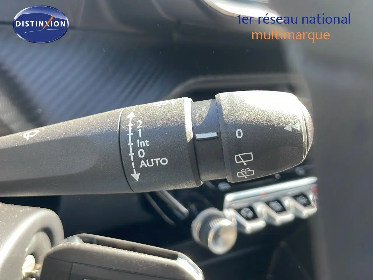 Le commodo d'essuie-glace du Peugeot 2008 2025 en gros plan, avec commandes visibles sur fond intérieur noir.