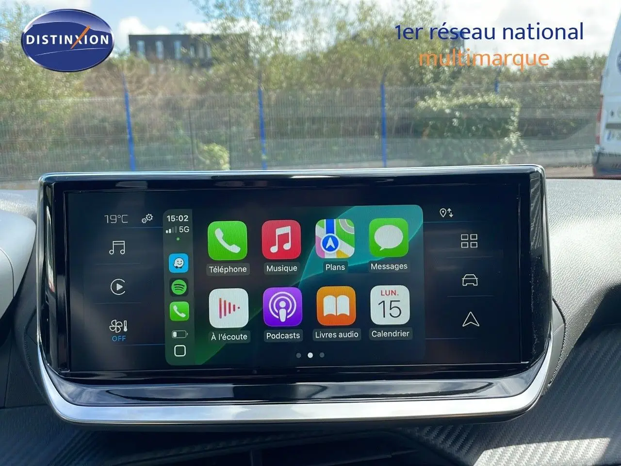 Écran tactile central du Peugeot 2008 2025 affichant les applications connectées, avec tableau de bord en arrière-plan.