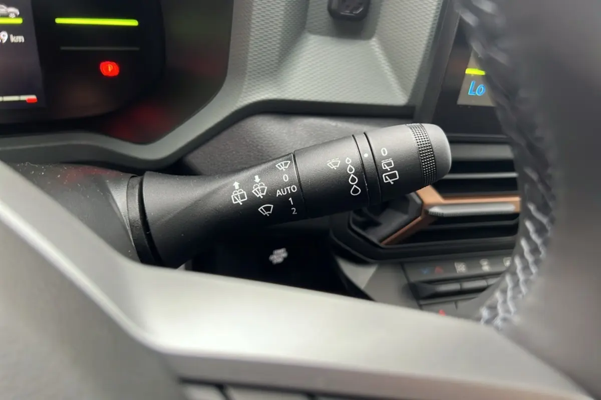 Gros plan sur la commande d'essuie-glace à gauche du volant du Dacia Duster 2025 kaki lichen, version TCE 130 4X2 Extreme Cold Tech.