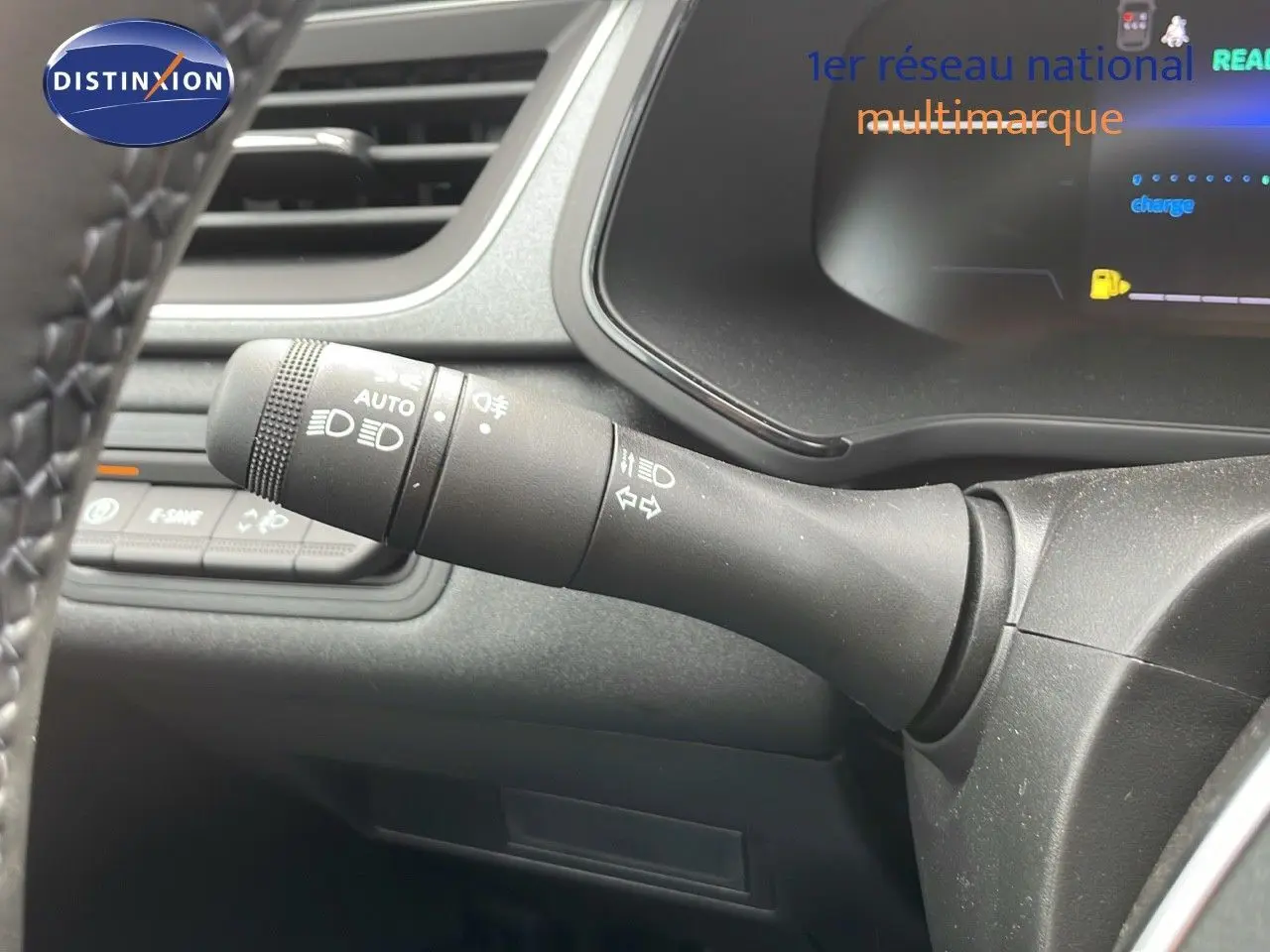 Gros plan sur la commande des phares et clignotants du tableau de bord d'un Renault Captur gris cassiopée 2025.