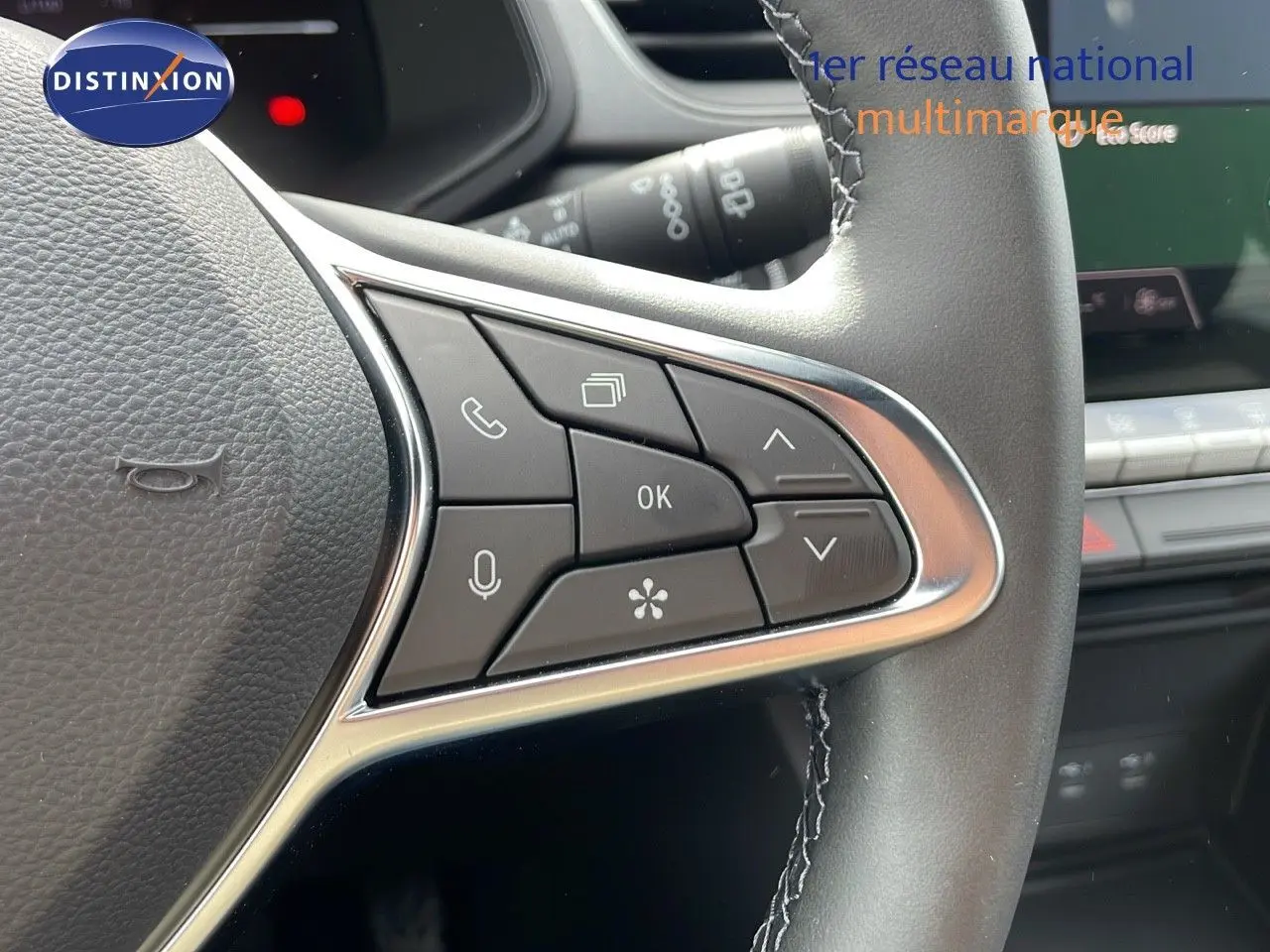 Gros plan sur les commandes à gauche du volant du Renault Captur gris Cassiopée, avec finition chrome et cuir noir.