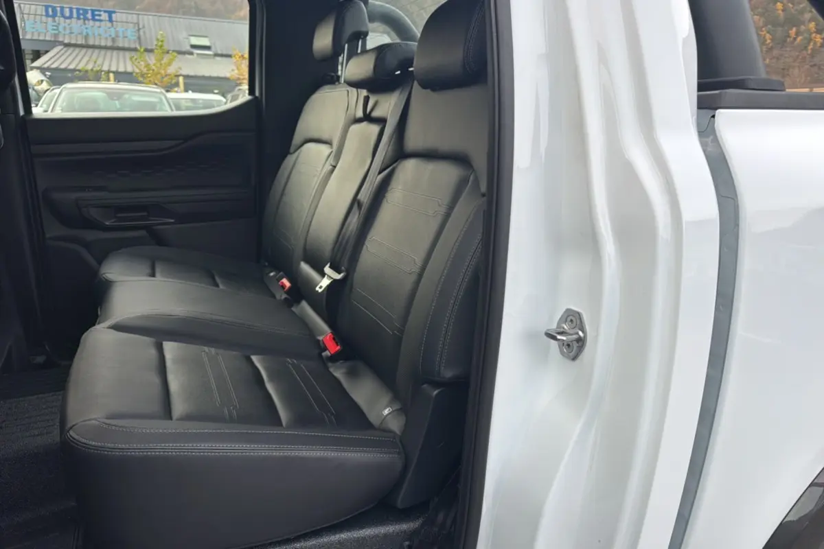 Vue latérale intérieure montrant la banquette arrière en cuir noir du Ford Ranger blanc glacier 2025 double cabine.