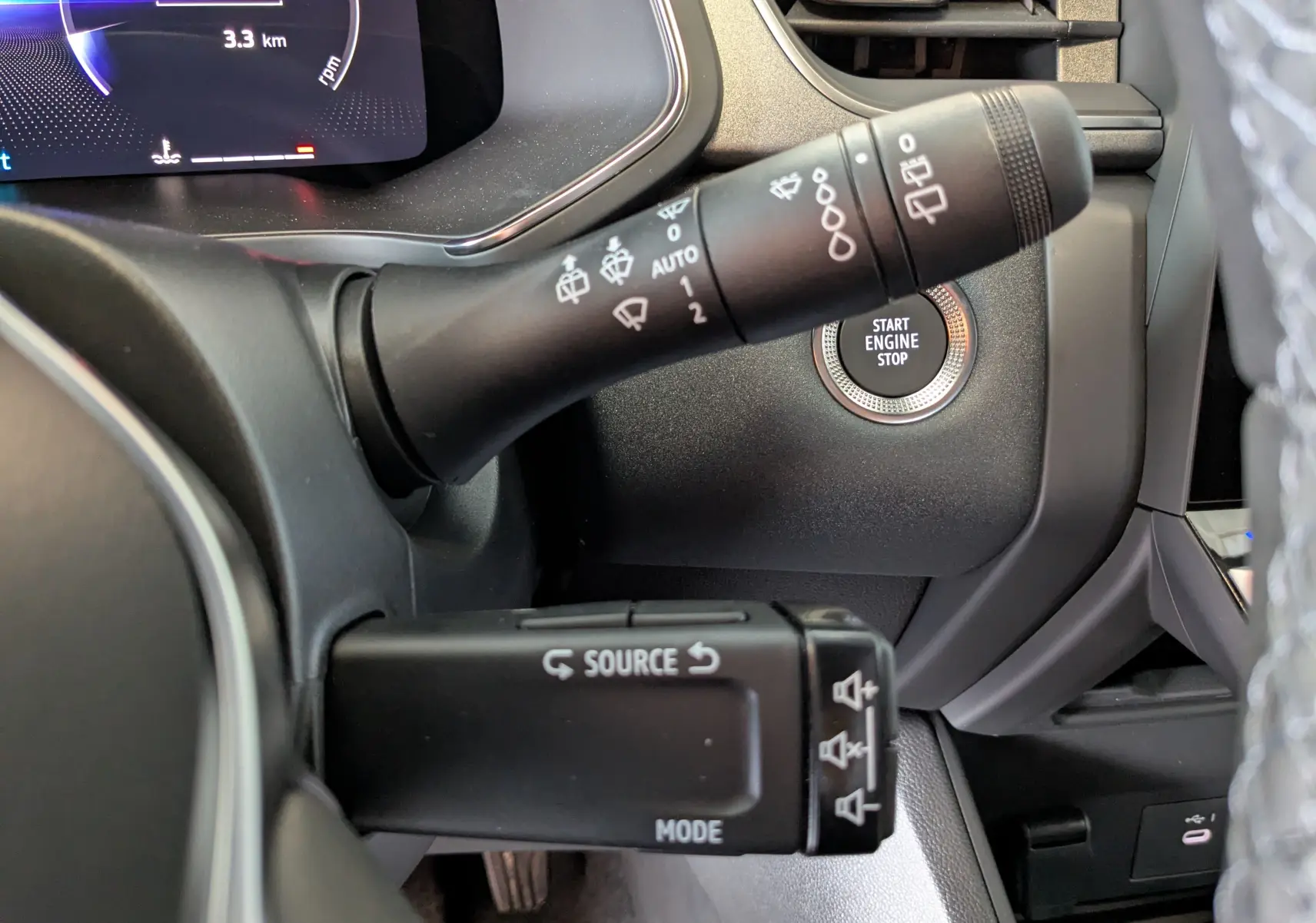 Gros plan sur la commande des essuie-glaces et bouton start/stop du tableau de bord du Renault Captur gris zinc 2025.