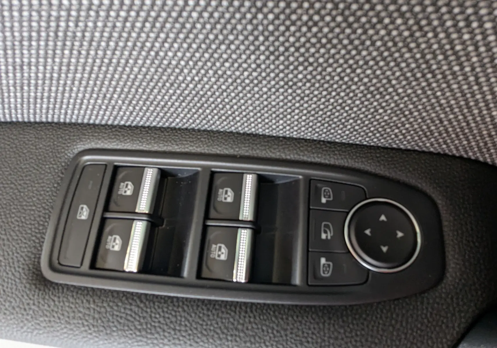 Panneau de commandes des vitres électriques et réglages des rétroviseurs côté conducteur du Renault Captur gris zinc 2025.