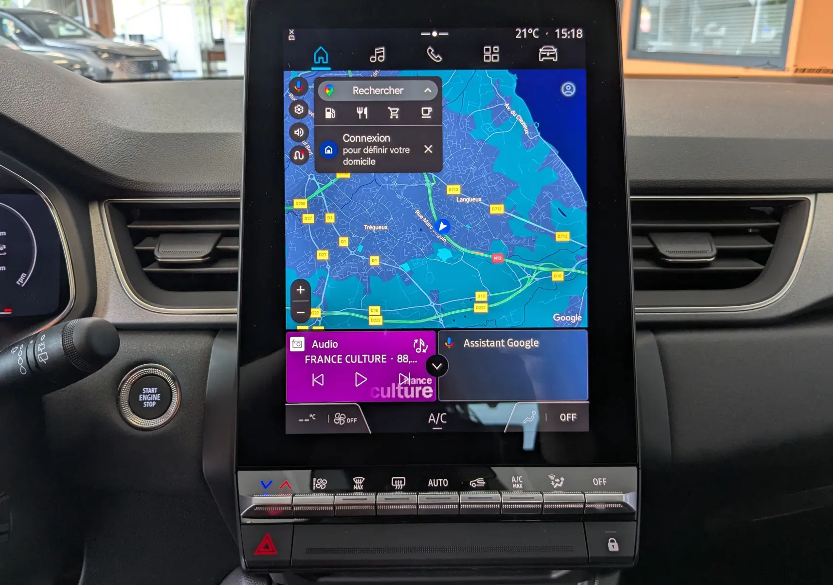 Écran tactile central allumé avec navigation GPS et commandes climatisation dans le tableau de bord d'un Renault Captur 2025.