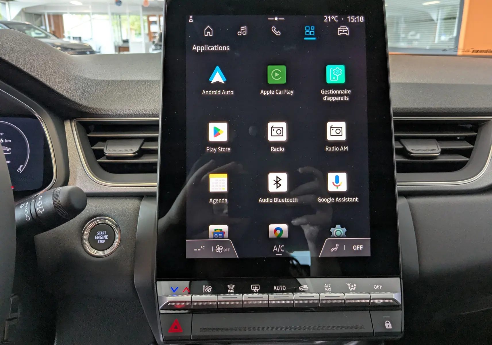 Écran tactile central du tableau de bord du Renault Captur 2025 affichant les applications connectées, avec bouton start/stop visible.