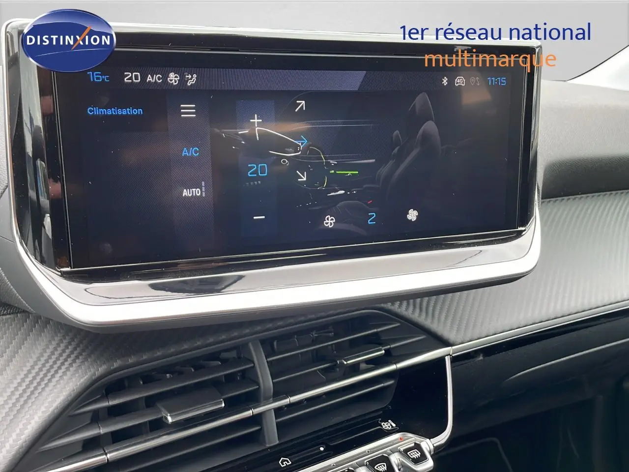 Écran tactile de la climatisation dans l'habitacle moderne d'une Peugeot 208 noire, vue de face rapprochée.