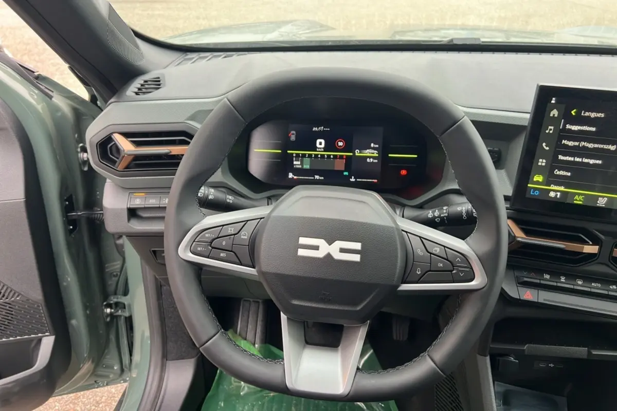 Vue intérieure centrée sur le volant et le tableau de bord numérique du Dacia Duster 2025 kaki lichen, version Extreme Cold Tech.