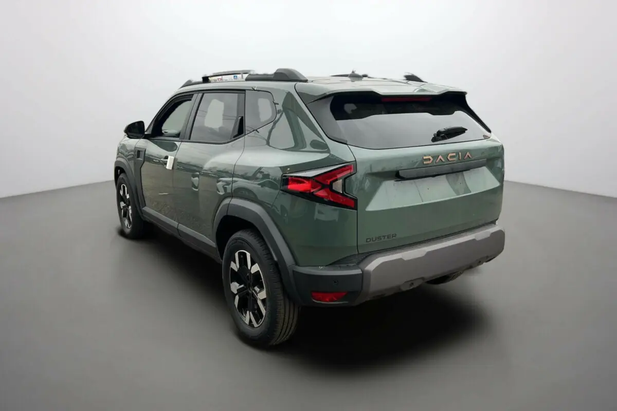 Vue 3/4 arrière droite du Dacia Duster 2025 kaki lichen avec logo cuivre et jantes noires distinctives.