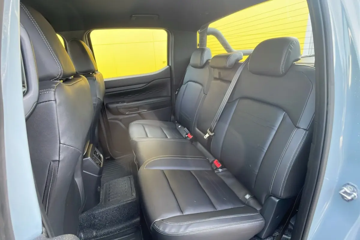Vue intérieure arrière côté droit du Ford Ranger 2025 avec sièges en cuir noir et arceau noir visible.
