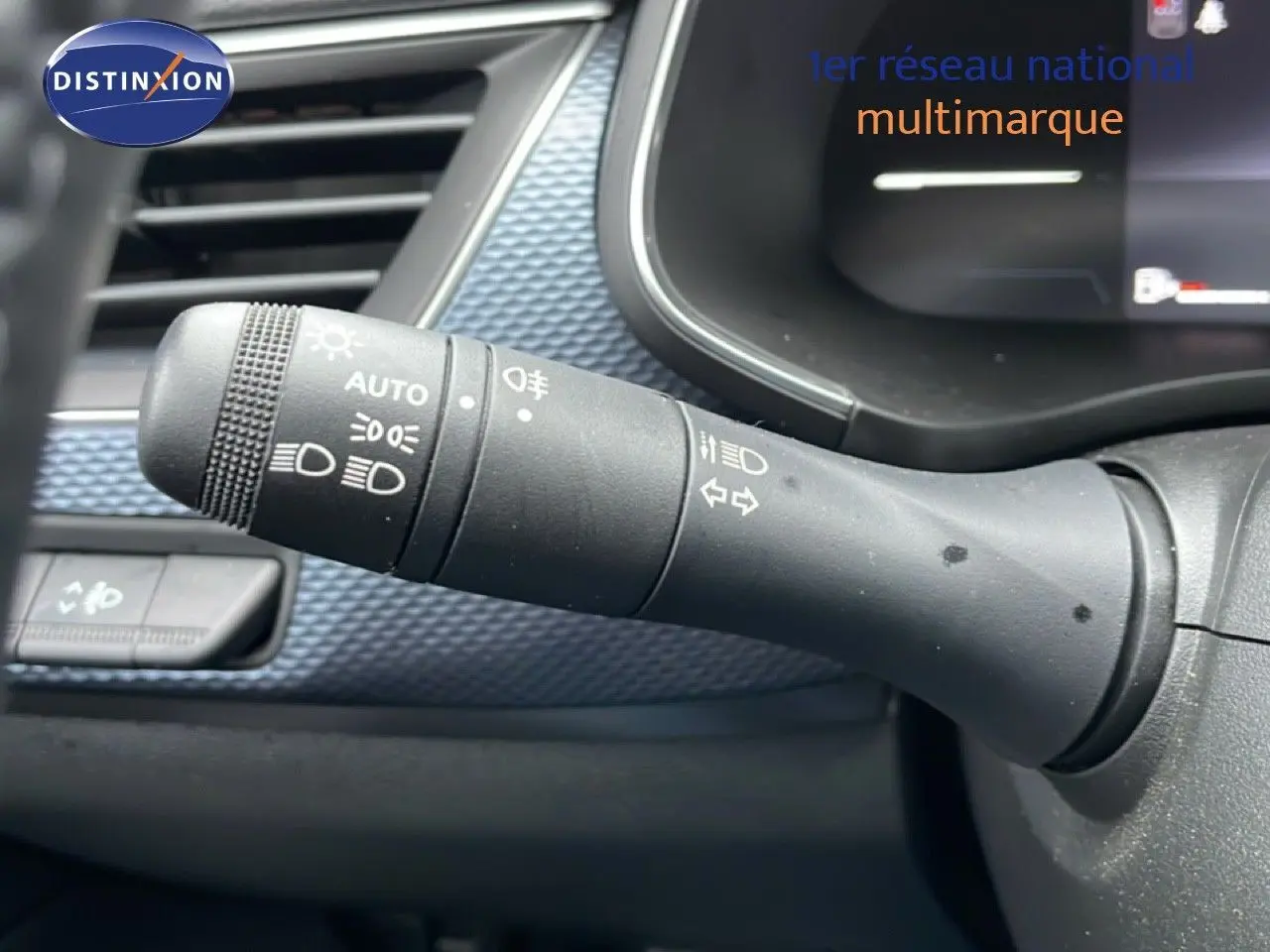 Gros plan sur la manette de commande des phares et clignotants dans l’habitacle du Renault Arkana bleu Zanzibar.