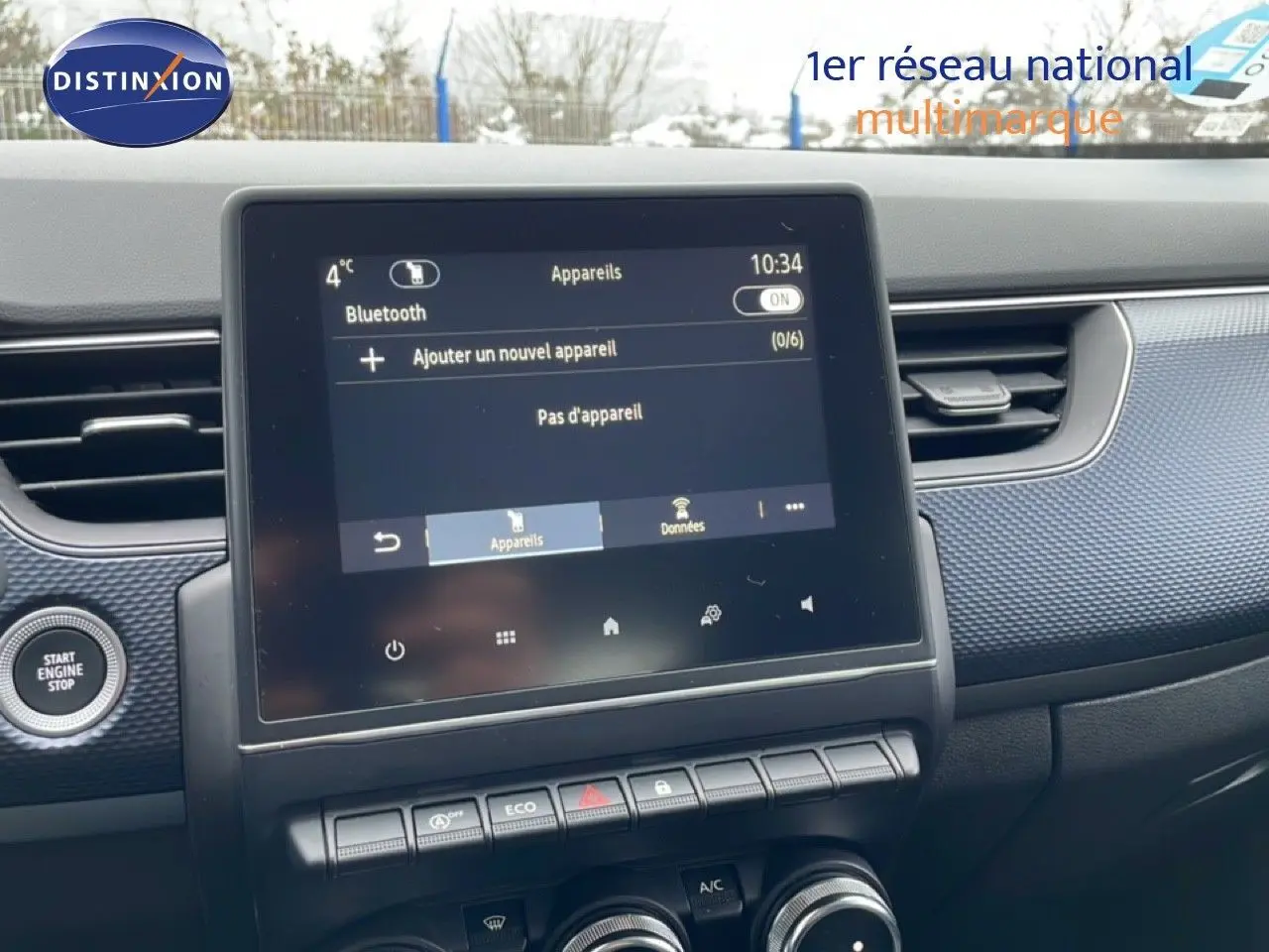 Vue intérieure centrée sur l'écran tactile et la console centrale du Renault Arkana bleu Zanzibar 2025.