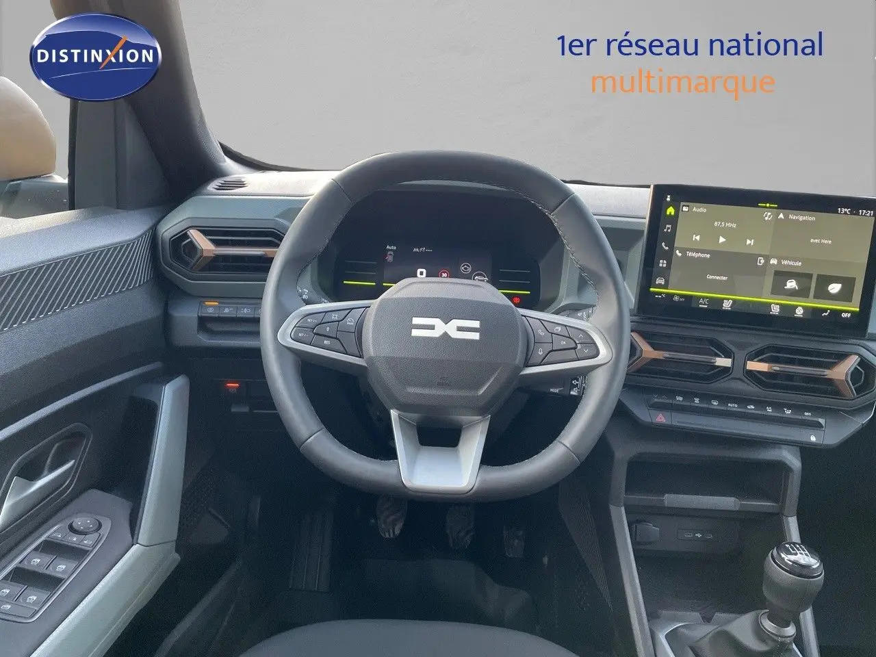 Vue intérieure du tableau de bord du Dacia Duster 2024 noir métal, avec volant multifonctions et écran tactile central.